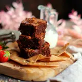 Gestapelte Brownies mit Nüssen und Schokostückchen, dazu frische Erdbeeren. Ein perfektes brownie rezept für Genießer.