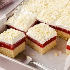 Schneeweiße Sahne und rote Fruchtschicht auf hellem Boden – dieser Frau Holle Kuchen sieht aus wie frisch aus dem Märchen!