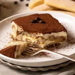 Ein Stück cremiges Tiramisu, das nach einem authentischen tiramisu rezept original italienisch schmeckt. Mit Löffelbiskuits, Mascarpone und Kakao.