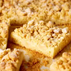 Saftiger Apfelkuchen mit Vanillepudding und knusprigen Streuseln, bestäubt mit Puderzucker. Ein Genuss für jeden Kaffeetisch.