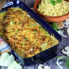 Herzhaftes Zwiebel Sahne Schnitzel mit Käse überbacken, daneben Spätzle und frische Zutaten.