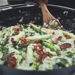 Cremiges Spargelrisotto mit Speck, zubereitet im Dutch Oven. Ein köstliches Gericht, das zeigt, wie vielseitig Dutch Oven Rezepte sind.