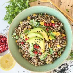 Bunter Quinoa Salat mit Avocado, Granatapfelkernen, Mais und Petersilie. Ein gesundes und erfrischendes Gericht.