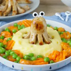Ein lustiges Oktopus-Würstchen auf Kartoffelbrei mit Erbsen und Karotten. Ein gesundes Mittagessen für Kinder, das Spaß macht!