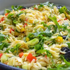 Frischer Kritharaki Salat mit Rucola, Tomaten, Gurken, Paprika, Oliven und Feta. Ein leichter Genuss!