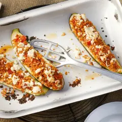 Gefüllte Zucchinihälften mit einer würzigen Couscous-Tomaten-Mischung und zerbröckeltem Feta. Ein raffiniertes vegetarisches Hauptgericht, das Appetit macht.