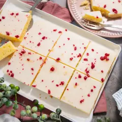 Saftiger veganer Kuchen mit weißer Glasur und roten Beerenstückchen, perfekt für jeden Anlass.