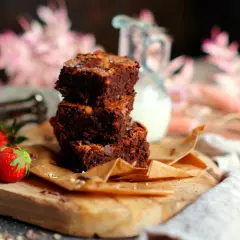 Gestapelte Brownies mit Nüssen und Schokostückchen, dazu frische Erdbeeren. Ein perfektes brownie rezept für Genießer.