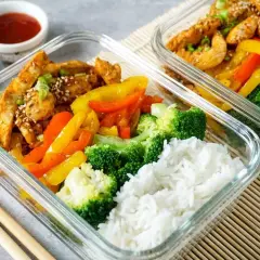 Zwei Glasbehälter mit Hähnchen, Paprika, Brokkoli und Reis. Perfekt für ein gesundes low carb mittagessen.