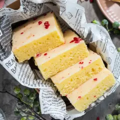 Saftige Kuchenstücke mit weißer Glasur und roten Streuseln, inspiriert von einem Tassenkuchen Rezept Blech.