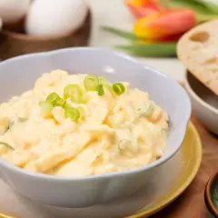 Cremiger eiersalat ohne mayo, garniert mit Frühlingszwiebeln, serviert mit Brot.