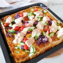 Herzhafte low carb rezepte einfach: Gebackene Tortilla mit Hackfleisch, Käse, Tomaten, Gurken, Rotkohl und Sauce.