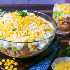 Schichtsalat-Rezept mit Miracel Whip: Ein bunter Salat aus Schichten von Gemüse, Ei, Schinken und Mais, gekrönt mit Käse.