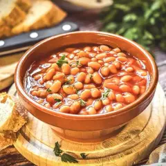 Herzhaftes baked beans rezept in einer Schüssel, garniert mit Petersilie, serviert mit frischem Brot.