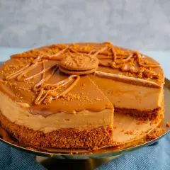 Ein köstlicher Lotus Cheesecake mit Karamellglasur und zerbröselten Keksen, dekoriert mit einem ganzen Keks.
