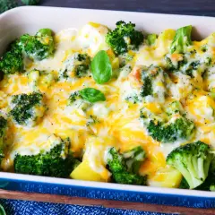 Herzhaftes Kartoffel Brokkoli Gratin, überbacken mit geschmolzenem Käse und garniert mit frischem Basilikum.