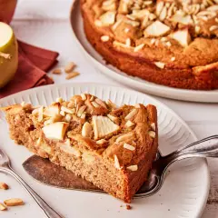 Ein Stück saftiger Apfelkuchen ohne Zucker, garniert mit Mandelblättchen und Apfelstücken. Ein Genuss für alle Sinne.