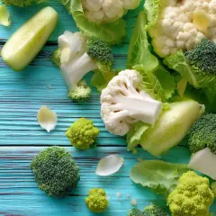 Frischer Brokkoli, Blumenkohl und Gurke auf blauem Holz – perfekt für eine low carb vegane Ernährung.