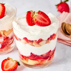 Erdbeer Tiramisu im Glas: Schichten aus Löffelbiskuits, frischen Erdbeeren und cremiger Mascarpone, garniert mit Erdbeerscheiben.