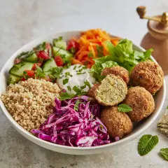 Schüssel mit Falafel, Couscous, Tomaten, Gurken, Rotkohl und Joghurt. Perfekt für gesunde Essen Rezepte.
