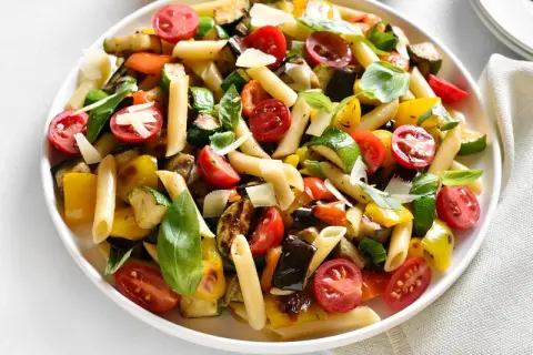 Buntes Nudelgericht mit gegrilltem Gemüse, Tomaten und Basilikum. Ein tolles nudelsalat rezept für den Sommer.