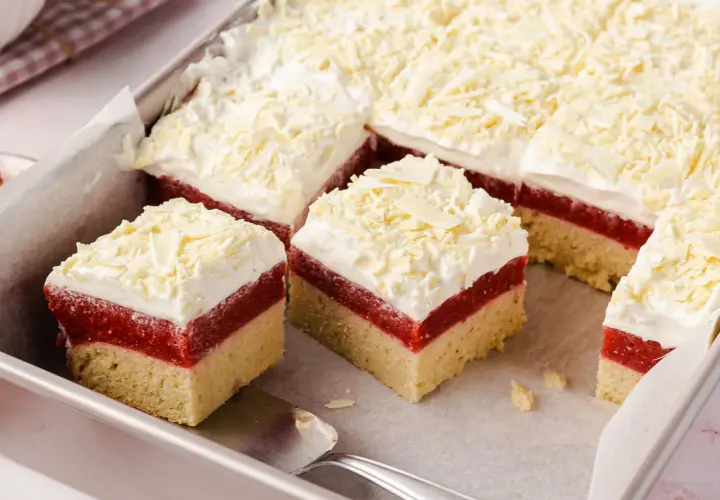 Schneeweiße Sahne und rote Fruchtschicht auf hellem Boden – dieser Frau Holle Kuchen sieht aus wie frisch aus dem Märchen!