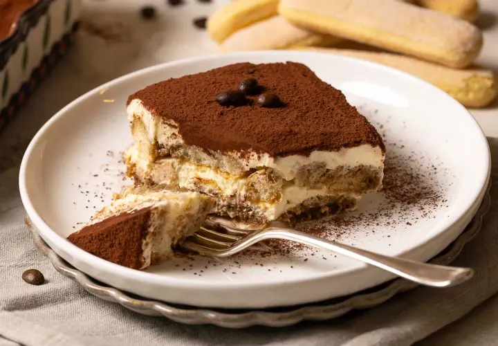 Ein Stück cremiges Tiramisu, das nach einem authentischen tiramisu rezept original italienisch schmeckt. Mit Löffelbiskuits, Mascarpone und Kakao.
