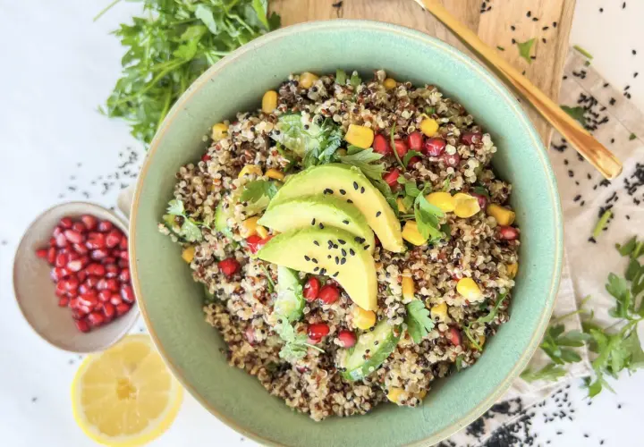 Bunter Quinoa Salat mit Avocado, Granatapfelkernen, Mais und Petersilie. Ein gesundes und erfrischendes Gericht.