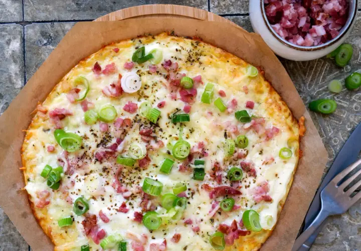 Leckerer low carb Flammkuchen mit Speck und Frühlingszwiebeln, goldbraun gebacken und bereit zum Genießen.