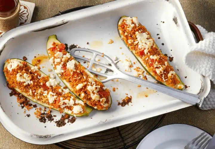 Gefüllte Zucchinihälften mit einer würzigen Couscous-Tomaten-Mischung und zerbröckeltem Feta. Ein raffiniertes vegetarisches Hauptgericht, das Appetit macht.