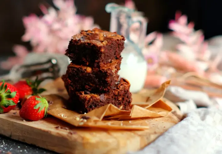 Gestapelte Brownies mit Nüssen und Schokostückchen, dazu frische Erdbeeren. Ein perfektes brownie rezept für Genießer.