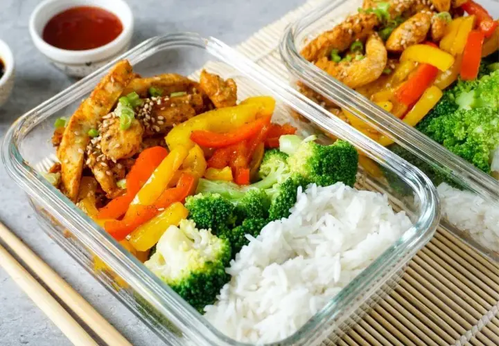 Zwei Glasbehälter mit Hähnchen, Paprika, Brokkoli und Reis. Perfekt für ein gesundes low carb mittagessen.