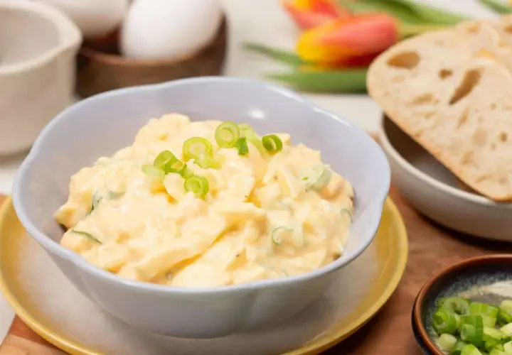 Cremiger eiersalat ohne mayo, garniert mit Frühlingszwiebeln, serviert mit Brot.