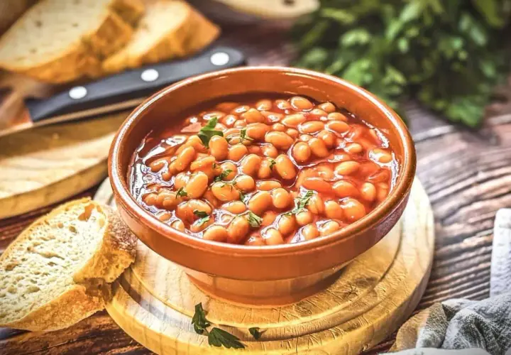 Herzhaftes baked beans rezept in einer Schüssel, garniert mit Petersilie, serviert mit frischem Brot.