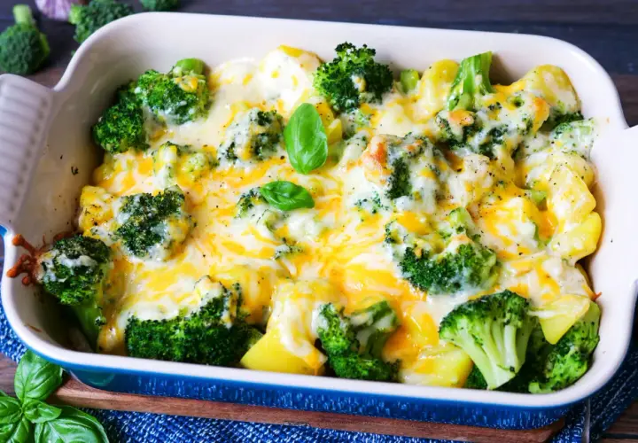 Herzhaftes Kartoffel Brokkoli Gratin, überbacken mit geschmolzenem Käse und garniert mit frischem Basilikum.
