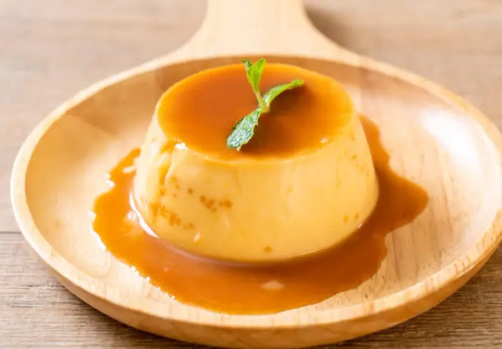 Cremiger Karamellpudding, perfekt zum Pudding selber machen. Mit Minze garniert auf einem Holztablett.