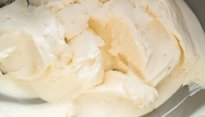 Cremige Buttercreme mit Pudding, die in einer Schüssel aufgeschlagen wird. Die Textur ist glatt und luftig, perfekt für Kuchen und Desserts.