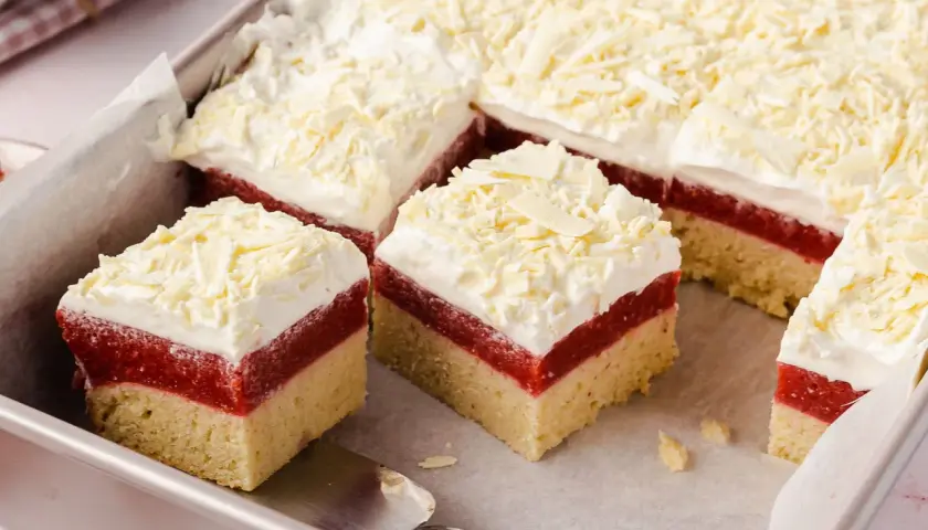 Schneeweiße Sahne und rote Fruchtschicht auf hellem Boden – dieser Frau Holle Kuchen sieht aus wie frisch aus dem Märchen!
