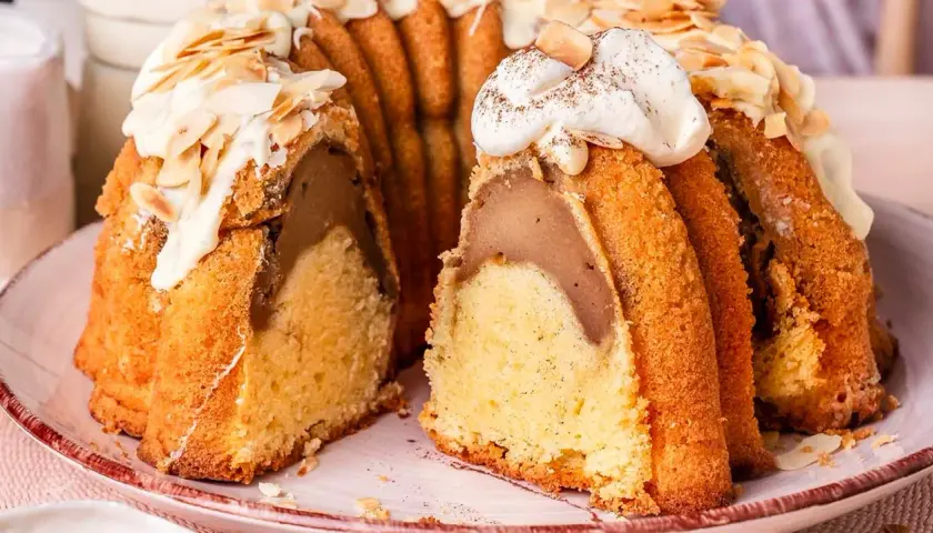 Ein saftiger Gugelhupf mit einer Füllung, verziert mit Sahne und Mandeln. Perfekt für einen sonntagskuchen schnell und einfach.
