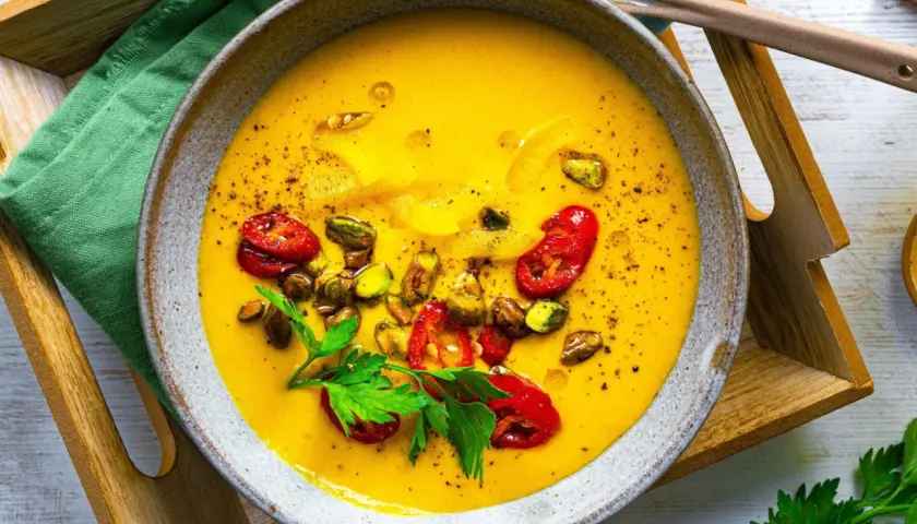 Leckere, gelbe Suppe mit Pistazien und Tomaten, ideal als eine der gesunden Suppen zum Abnehmen.
