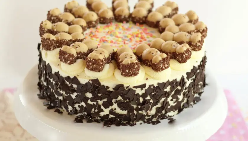Eine Sahnetorte mit Schokostückchen und süßen Figuren obendrauf. Perfekt für geile Torten Rezepte!