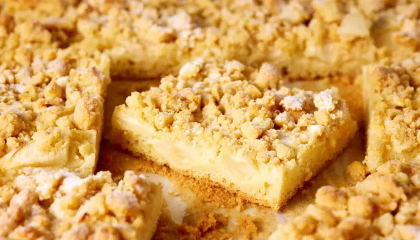 Saftiger Apfelkuchen mit Vanillepudding und knusprigen Streuseln, bestäubt mit Puderzucker. Ein Genuss für jeden Kaffeetisch.