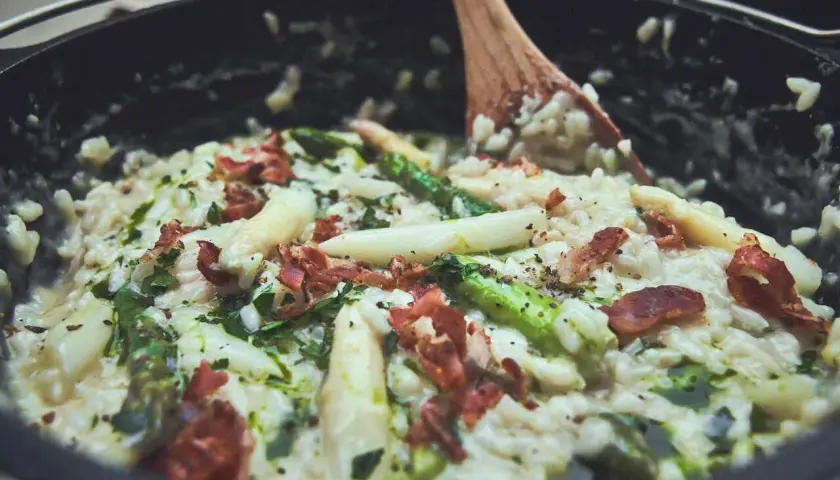 Cremiges Spargelrisotto mit Speck, zubereitet im Dutch Oven. Ein köstliches Gericht, das zeigt, wie vielseitig Dutch Oven Rezepte sind.