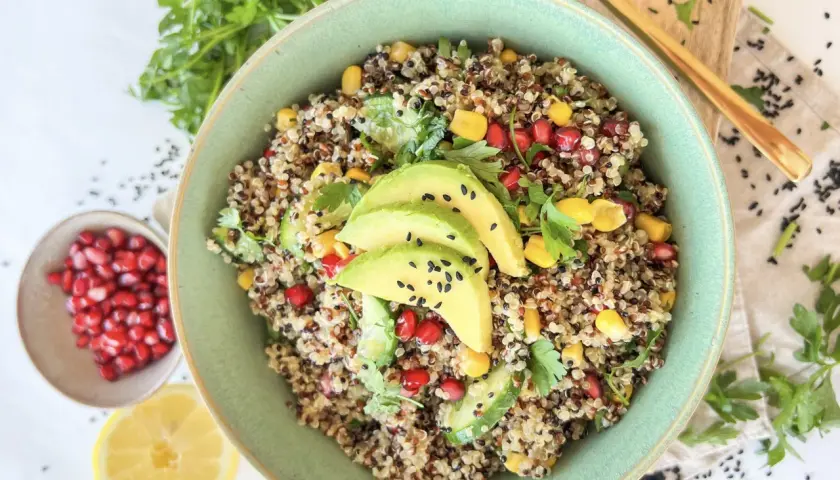 Bunter Quinoa Salat mit Avocado, Granatapfelkernen, Mais und Petersilie. Ein gesundes und erfrischendes Gericht.