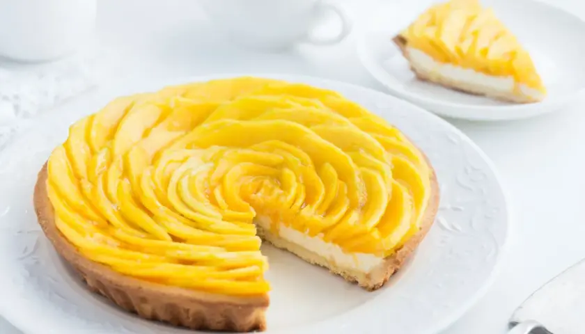 Ein wunderschöner Mango-Tarte, der einen einfachen und raffinierten nachtisch darstellt. Die Mango-Scheiben sind kunstvoll zu einer Rose arrangiert.