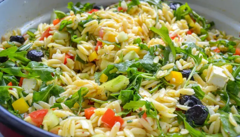 Frischer Kritharaki Salat mit Rucola, Tomaten, Gurken, Paprika, Oliven und Feta. Ein leichter Genuss!