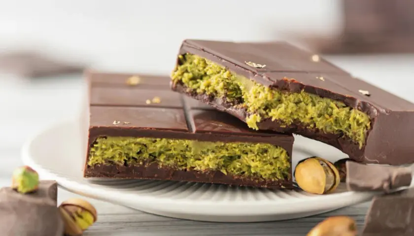 Schokolade mit Pistazienfüllung, inspiriert vom Dubai Schokolade Rezept. Goldene Blättchen zieren die dunkle Schokolade.