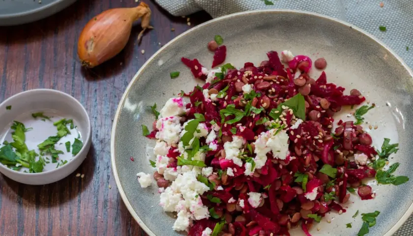 Ein bunter rote Bete Linsen Salat mit Feta und frischer Petersilie, garniert mit Sesam.