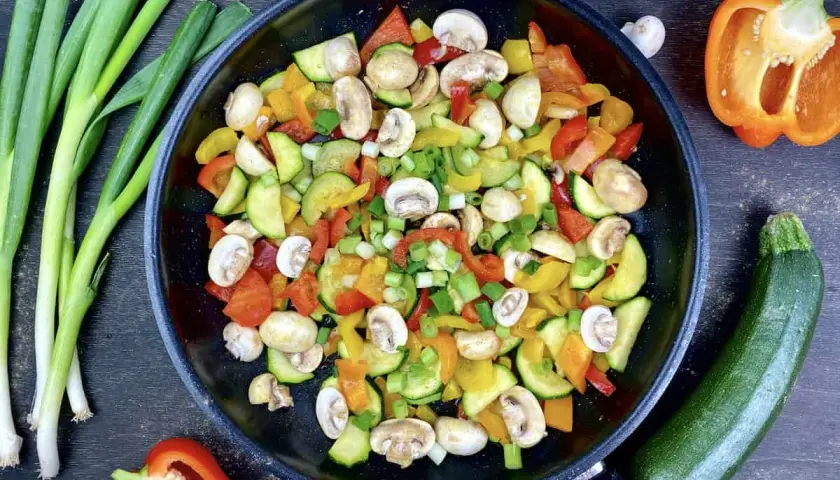 Buntes Gemüse in der Pfanne, perfekt für ein leichtes Abendessen mit wenig Kalorien. Zucchini, Paprika und Pilze werden mit Frühlingszwiebeln verfeinert.