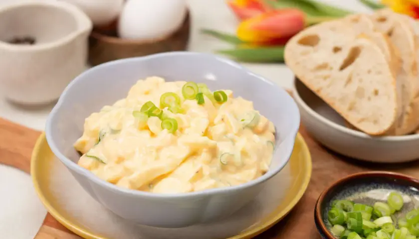 Cremiger eiersalat ohne mayo, garniert mit Frühlingszwiebeln, serviert mit Brot.